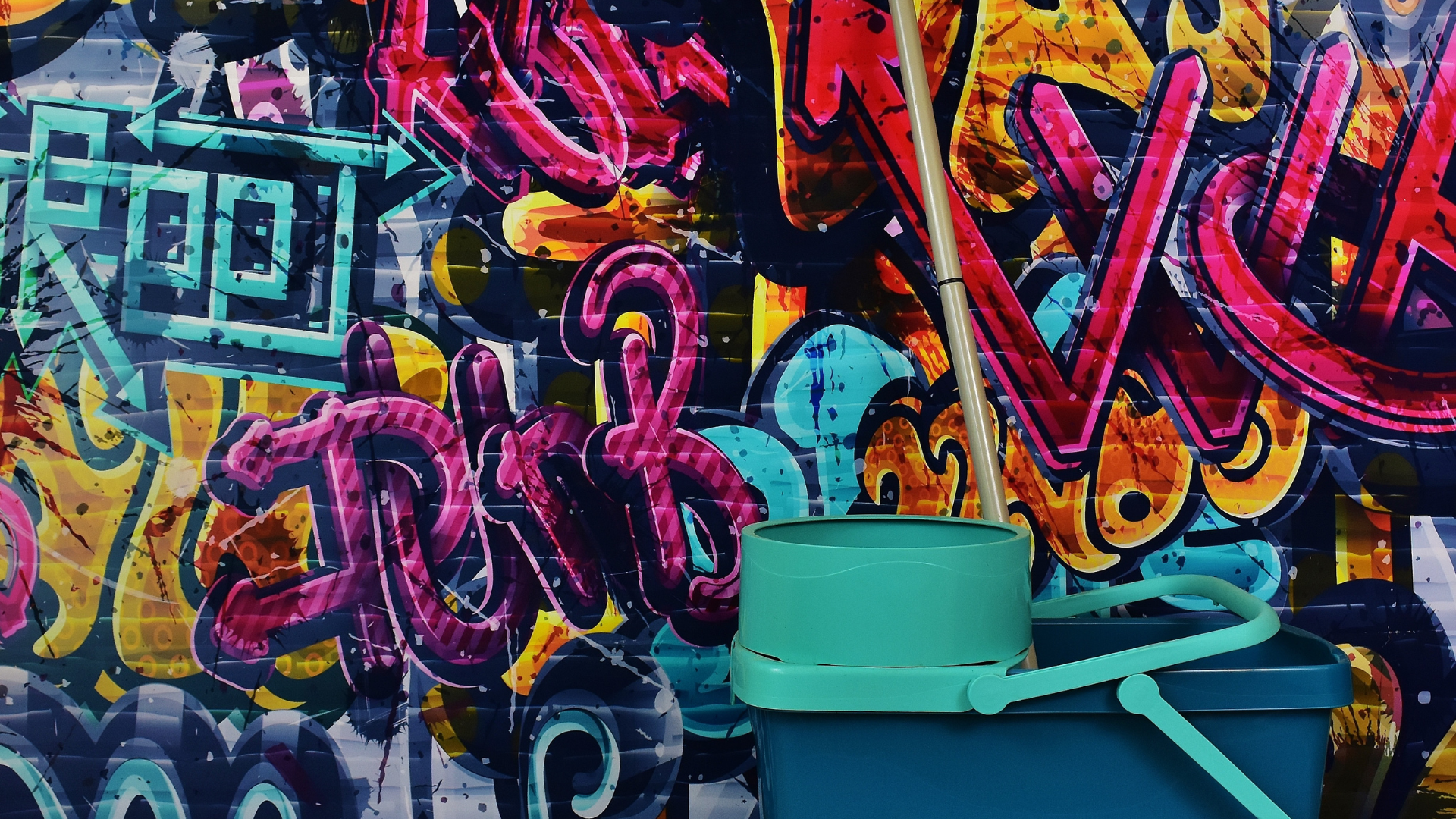 Graffiti om wall and cleaning bucket on floor